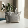 Bolso tote plateado con acabado metalizado y asas superiores