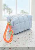 Neceser acolchado quilted azul celeste con llavero neon naranja y verde mint cremallera blanca