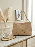 Bolso beige con tachuelas doradas y asa corta