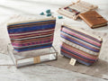 Neceser étnico de rayas boho artesanal multicolor en tonos azul rosa y tierra