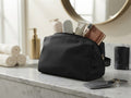 Neceser grande negro unisex Soft Touch Travel con cremallera dorada sobre encimera de baño